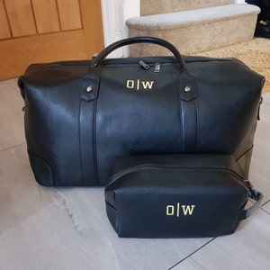 May include: Black leather travel bag and matching toiletry bag with gold monogram "O|W" on both.