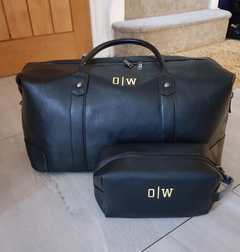 May include: Black leather travel bag and matching toiletry bag with gold monogram "O|W" on both.