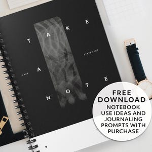 May include: A black spiral-bound notebook with the words "TAKE A NOTE" in white. A watch with a black band and gold-colored case is next to the notebook. A black zippered pouch is also visible. A white circle with text reads "FREE DOWNLOAD NOTEBOOK USE IDEAS AND JOURNALING PROMPTS WITH PURCHASE."