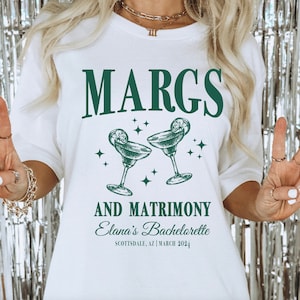 May include: White t-shirt with green text that reads "MARGS AND MATRIMONY Elana's Bachelorette Scottsdale, AZ | March 2024". The shirt also features two green margarita glasses with lime wedges.