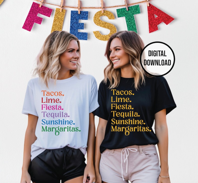 以下が含まれることがあります： 「Tacos. Lime. Fiesta. Tequila. Sunshine. Margaritas.」とプリントされた白と黒のTシャツを着た2人の女性。テキストは虹色です。女性たちは笑顔でカメラを見ています。背景は、「FIESTA」と綴られたカラフルな文字のガーランドが飾られた白い壁です。