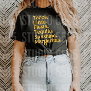以下が含まれることがあります： 「Tacos. Lime. Fiesta. Tequila. Sunshine. Margaritas.」と黄色い文字が書かれた黒いTシャツ
