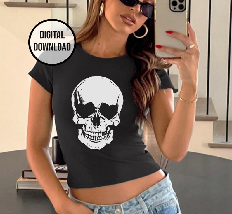 May include: A black cropped t-shirt with a white skull graphic wearing sunglasses. The skull has a toothy grin.