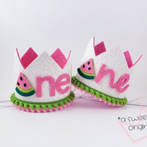 May include: A white felt crown with pink felt trim and green pom-poms. The crown has a pink felt "one" with a watermelon graphic on the side.