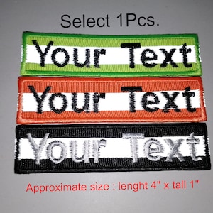 May include: Three embroidered patches with white reflective stripes. The patches are green, orange, and black. Each patch says "Your Text" and measures 4 inches long by 1 inch tall.
