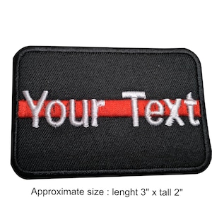 May include: Black embroidered patch with a red stripe and white text that says "Your Text". The patch is approximately 7.6 cm long and 5.1 cm tall.