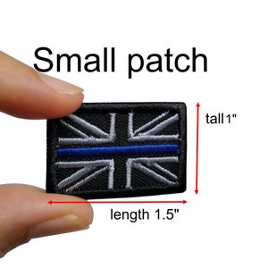 May include: A small black patch with a blue line and a white and gray Union Jack design. The patch is 1 inch tall and 1.5 inches long.
