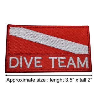 Puede incluir: Parche bordado rojo y blanco con una franja blanca diagonal y el texto "DIVE TEAM". El parche mide aproximadamente 8,9 cm de largo y 5,1 cm de alto.