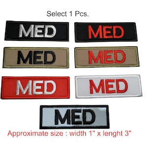 Könnte beinhalten: Sechs verschiedene Farbvarianten eines "MED"-Patches. Die Patches sind rechteckig und haben weiße, schwarze und rote Beschriftung. Die Patches sind etwa 2,5 cm breit und 7,5 cm lang. Wählen Sie 1 Stück.