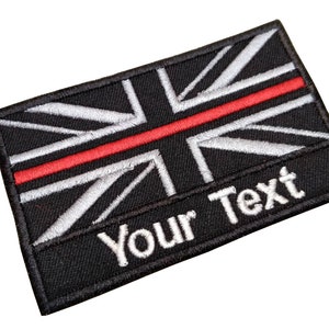 May include: Black and white embroidered Union Jack flag patch with a red stripe across the middle and the text "Your Text" below.