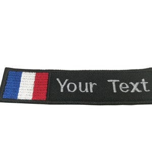 May include: Black embroidered patch with a French flag on the left side and the text "Your Text" in white on the right side.