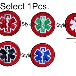 May include: Five red embroidered patches with a white medical symbol, each with a different coloured centre: black, green, blue, white, and red. The patches are 4 cm in diameter. Select 1Pcs.