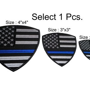 Könnte beinhalten: Drei gestickte Aufnäher in Schildform mit amerikanischem Flaggenmuster und einem blauen Streifen. Die Aufnäher sind in drei Größen erhältlich: 10 cm x 10 cm, 7,5 cm x 7,5 cm und 5 cm x 5 cm. Wählen Sie 1 Stück.