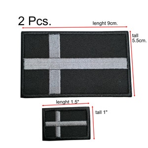 May include: Two black rectangular patches with a white cross design. The larger patch is 3.5 inches long and 2.2 inches tall. The smaller patch is 1.5 inches long and 1 inch tall. The text "2 Pcs." is above the patches.