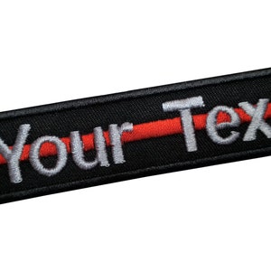May include: Black rectangular patch with the words "Your Text" embroidered in white, bisected by a red line. The patch is designed to be sewn or ironed onto fabric, suitable for customization.