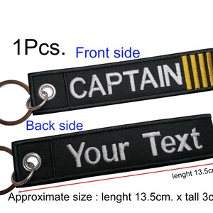 May include: Black key chain with a white embroidered "CAPTAIN" on the front and a blank space for text on the back. The key chain is 13.5 inches long and 3 inches tall.