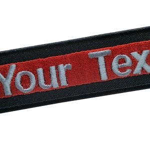 May include: Black and red embroidered patch with the text "Your Text" in white.