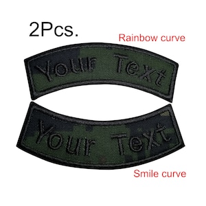 Peut inclure: Deux patchs brodés noirs avec un fond camouflage. Les patchs sont en forme de sourire et de courbe arc-en-ciel. Le texte "Your Text" est brodé sur chaque patch.