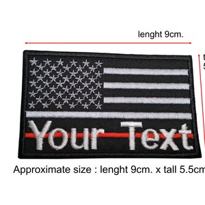 May include: Black and white embroidered American flag patch with a red stripe and the text "Your Text" below. The patch is approximately 3.5 inches wide and 2.2 inches tall.