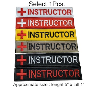 May include: Six embroidered patches with a red cross and the word "INSTRUCTOR" in white, red, yellow, brown, white, and red lettering. The patches are approximately 5 inches long and 1 inch tall.