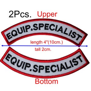 Könnte beinhalten: Zwei weiße gestickte Patches mit roten Rändern. Die Patches sind gebogen und sagen "EQUIP.SPECIALIST" in schwarzen Buchstaben. Die Patches sind 10 cm lang und 2 cm hoch.