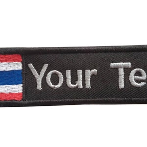 Puede incluir: Parche bordado negro con la bandera de Tailandia a la izquierda y el texto "Your Text" a la derecha.