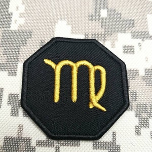 May include: Black octagon-shaped patch with a gold embroidered Virgo zodiac symbol.