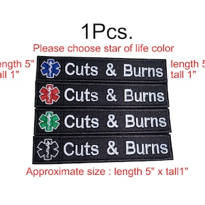 Op de afbeelding: Zwarte geborduurde patches met de tekst "Cuts & Burns" en een Star of Life-symbool in verschillende kleuren: blauw, rood, groen en wit. Elke patch is ongeveer 12,7 cm lang en 2,5 cm hoog.