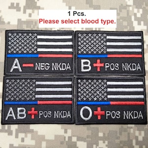 May include: Four black embroidered patches with an American flag design. Each patch has a different blood type: A-NEG NKDA, B+ POS NKDA, AB+ POS NKDA, O+ POS NKDA.