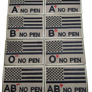 May include: Eight embroidered patches with American flag designs. Each patch features a blood type: A-, A+, B-, B+, O-, O+, AB-, AB+. The text "NO PEN" is below each blood type.
