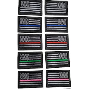 Puede incluir: Dos juegos de 10 parches de bandera estadounidense de línea fina. Cada parche presenta un fondo negro con estrellas y rayas blancas. La línea fina es de un color diferente: gris, azul, rojo, verde, rosa y amarillo.