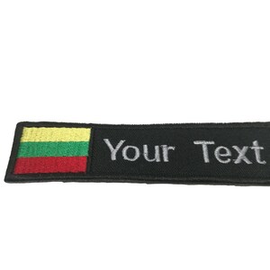 May include: A rectangular black patch with the text "Your Text" embroidered in white. The patch features the flag of Lithuania on the left side, with yellow, green, and red horizontal stripes.