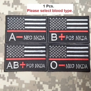 May include: Four black embroidered patches with an American flag design and red stripes. Each patch has a different blood type: A-NEG NKDA, B+ POS NKDA, AB+ POS NKDA, O-NEG NKDA.