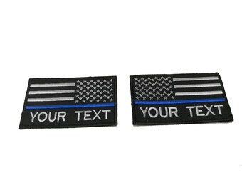 2 st. Anpassat namn, tunt blått polismärke med USA-flagga, krokbaksida för fastsättning eller sy-på, storlek 9x5,5 cm