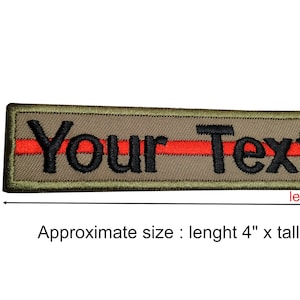 Puede incluir: Parche bordado con el texto "Your Text" en negro, una raya roja y un fondo caqui. El parche es rectangular, mide aproximadamente 10 cm de largo y 2,5 cm de alto.