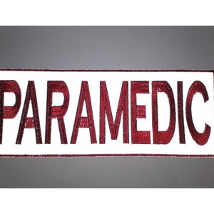 May include: White embroidered patch with the word "PARAMEDIC" in red lettering.