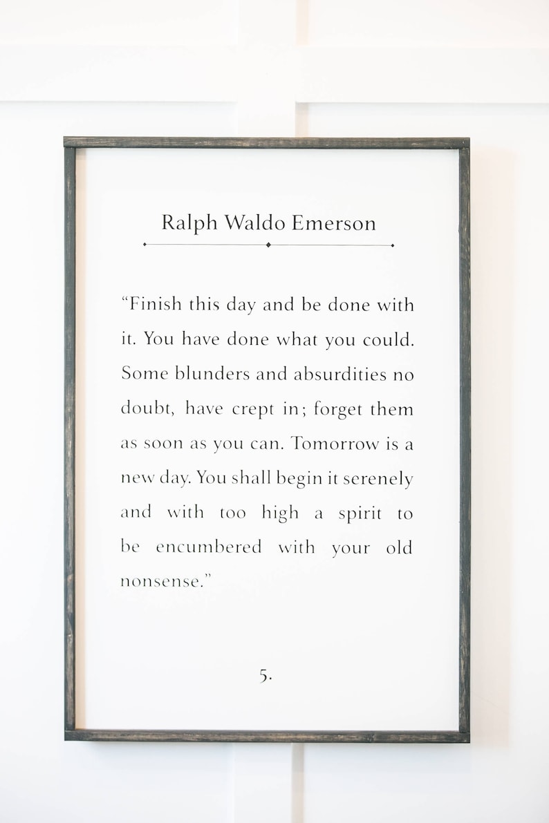 May include: Black and white framed print with a quote by Ralph Waldo Emerson. The quote reads: "Finish this day and be done with it. You have done what you could. Some blunders and absurdities no doubt, have crept in; forget them as soon as you can. Tomorrow is a new day. You shall begin it serenely and with too high a spirit to be encumbered with your old nonsense." The number 5 is printed below the quote.