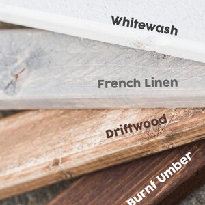 May include: Close-up of four wooden planks showcasing different finishes: Whitewash, French Linen, Driftwood, and Burnt Umber. The Sophistiqa logo is at the bottom. The planks are angled, revealing their textures and colors.