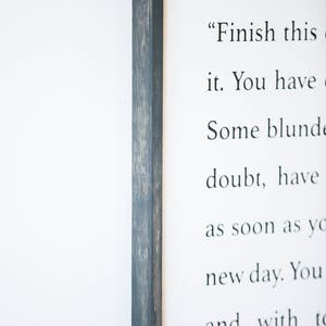 May include: A framed print with a black wood frame and a white background. The print features a quote that reads "Finish this it. You have Some blunde doubt, have as soon as yo new day. You and with to be encumbe"
