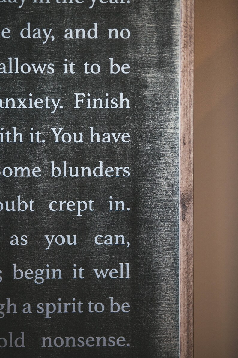 May include: Black wooden sign with white text that reads: "e day, and no allows it to be anxiety. Finish ith it. You have ome blunders oubt crept in. as you can, begin it well gh a spirit to be old nonsense."