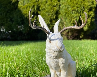 Siedząca statua jackalope w pozie „czekoladowego króliczka”.