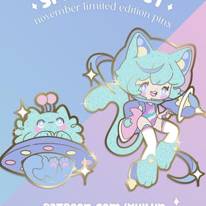 May include: Two Space Cadet pins with a cat theme. One pin features a cat in a spaceship, the other a cat in a space suit. The pins are light blue with gold accents and glitter. Text on the image reads "Space Cadet" and "November limited edition pins."