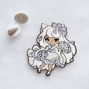 May include: A white enamel pin featuring a cartoon character with long white hair, wearing a white and purple dress and holding a fan. The character has a flower on her head and is surrounded by white petals.