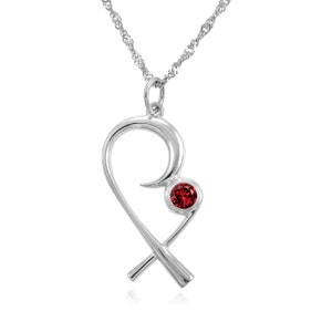 May include: A silver-toned pendant necklace featuring a heart-shaped design with a single, round, red gemstone. The pendant hangs from a delicate chain.