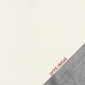 May include: A close-up of a white fabric with a diagonal gray fabric section. The gray fabric has a textured surface. The text "print detail" is written in red on the white fabric.