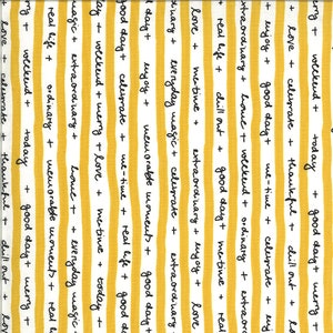 May include: Yellow and white striped fabric with black handwritten text. The text includes phrases like "good day", "love", "celebrate", "extraordinary", "real life", "me-time", "everyday magic", "memorable moments", "weekend", "today", "thankful", "chill out", and "merry".