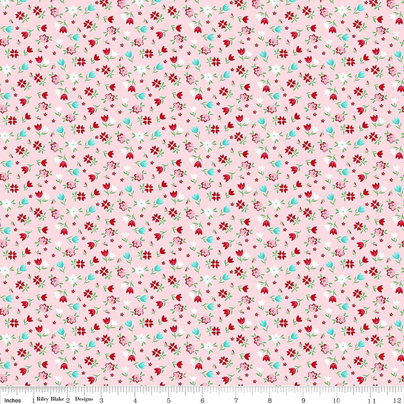 May include: A pink fabric with a repeating pattern of small red, white, and blue flowers. The fabric is perfect for quilting, crafting, and other sewing projects.