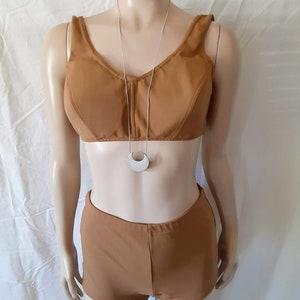 May include: A brown two-piece swimsuit with a halter top and high-waisted shorts. The swimsuit is on a white mannequin.