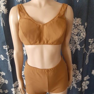 May include: A two-piece swimsuit in a brown colour. The top is a halter style with a V-neck and the bottom is a high-waisted short.