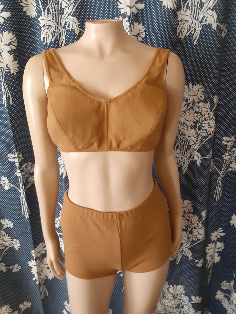 May include: A two-piece swimsuit in a brown colour. The top is a halter style with a V-neck and the bottom is a high-waisted short.